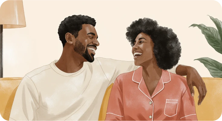 A couple is sitting on a sofa and laughing wondering how to get out of the friend zone
